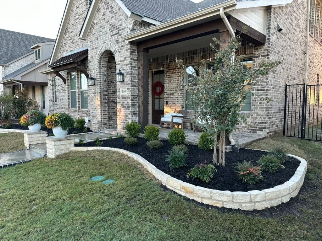 Modern home exterior with landscaped garden, brick facade, and seasonal decorations.
